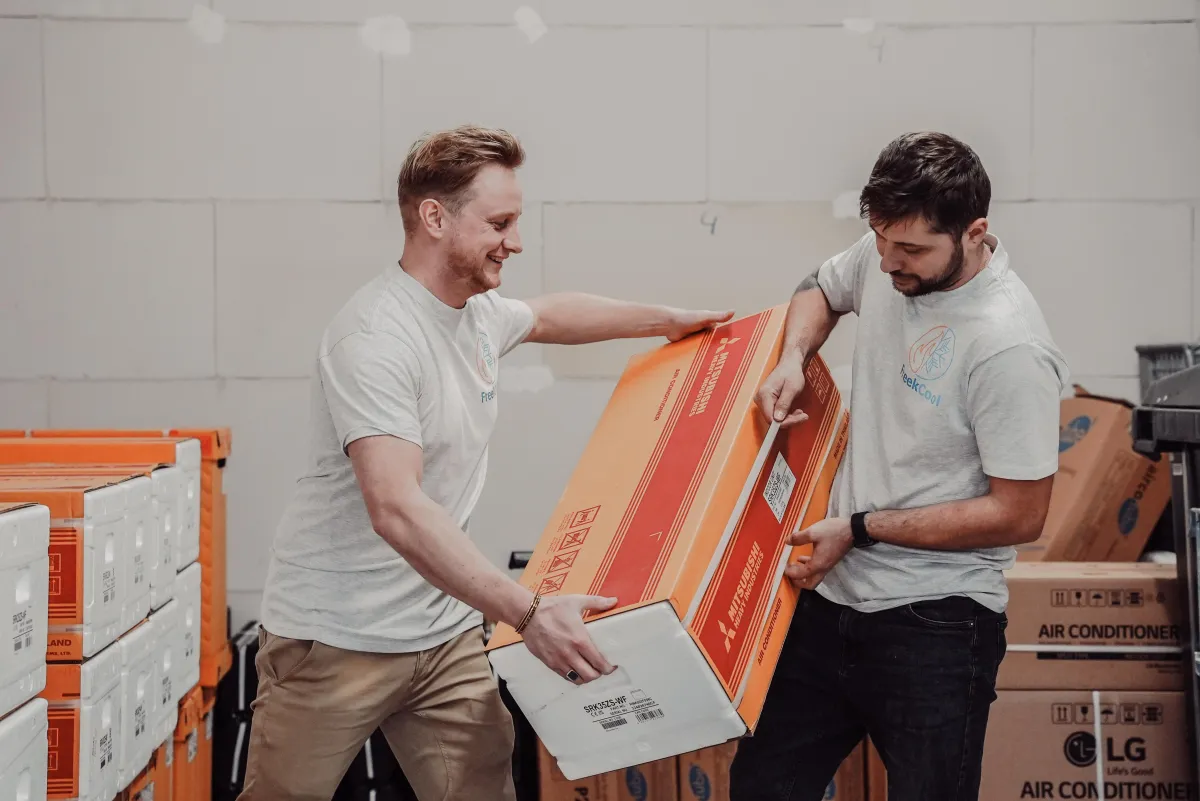 FreekCool-team met een airco in het magazijn